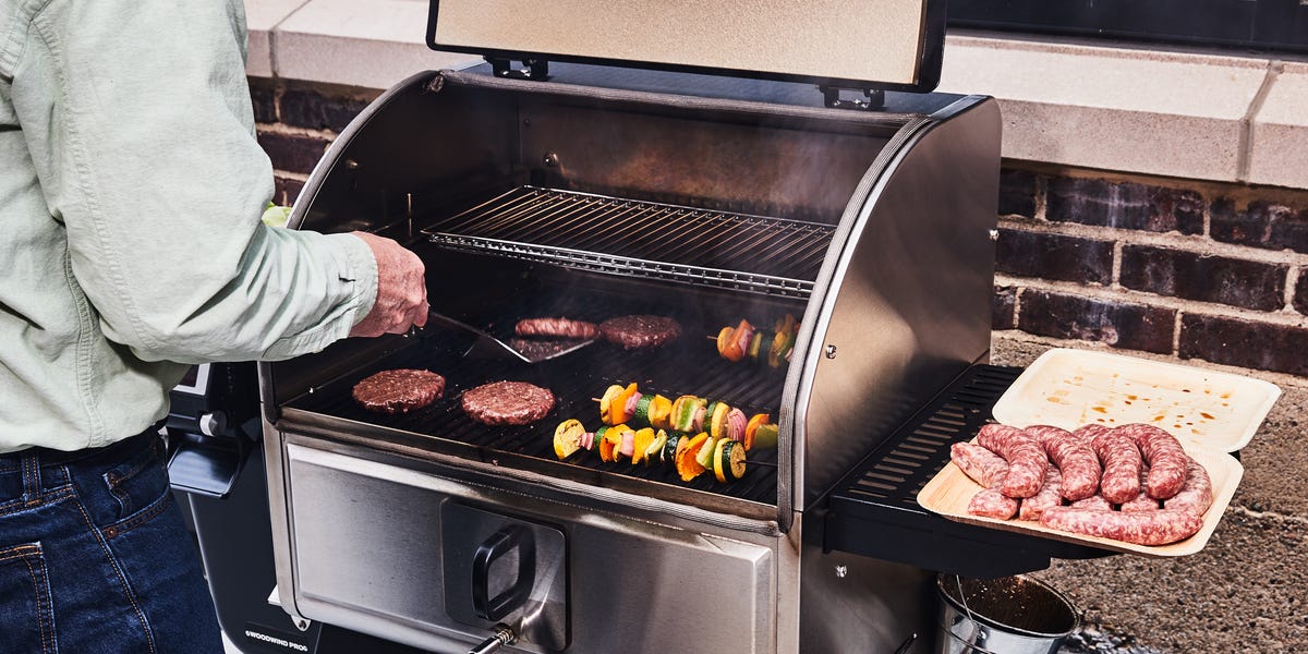 flipping hamburgers on grill with vegetables flipping hamburgers on grill with vegetables