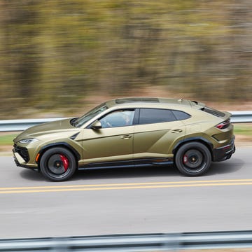 pan shot of lamborghini urus se driving down the road pan shot of lamborghini urus se driving down the road